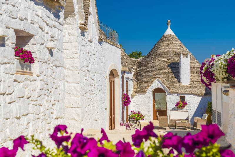trulli houses with flowers in Alberobello UNESCO district